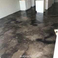 an empty room with black acid stain on the floor and white doors in the background