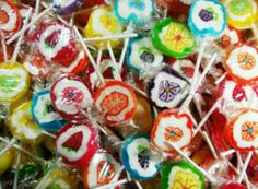 many colorful lollipops are sitting on top of each other