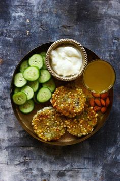 a plate filled with cucumbers, carrots and other foods