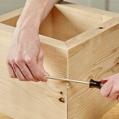 a person using a drill to attach the sides of a wooden box