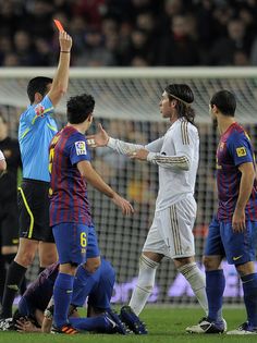 several soccer players are on the field and one player is holding his hand up in the air