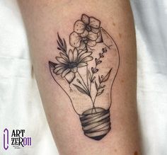 a black and white photo of a light bulb with flowers in it on the leg