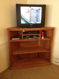 an entertainment center with a flat screen tv on it's stand, in front of a wall