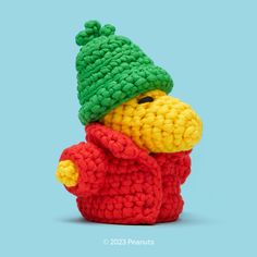 a crocheted stuffed animal wearing a green and red hat