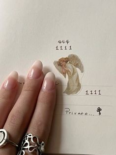 a woman's hand holding onto a piece of paper with an angel on it