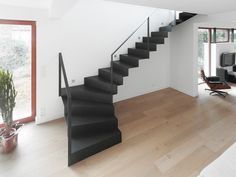 an open living room with stairs leading up to the second floor