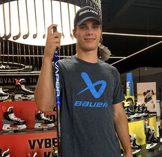 a young man holding up a pair of skis