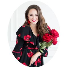 a woman holding flowers in her hand and smiling at the camera with a white background