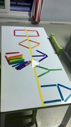 a white table with colored pencils on it