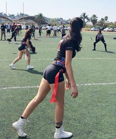 the girls are practicing their moves on the field with red ribbon tied around their ankles