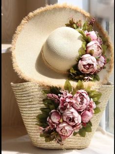 two straw hats with flowers on them sitting next to each other in front of a window