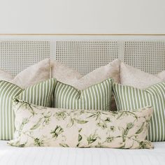 a bed with green and white pillows on it