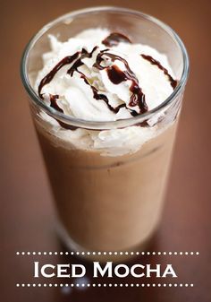 an iced mocha with whipped cream and chocolate drizzle on the top is shown