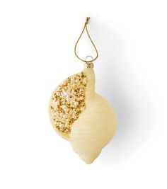 an ornament is hanging from a string on a white background with gold beads