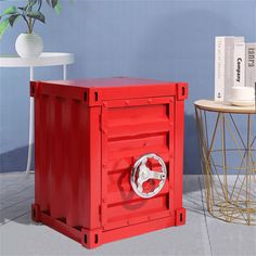 a red box sitting on top of a floor next to a table