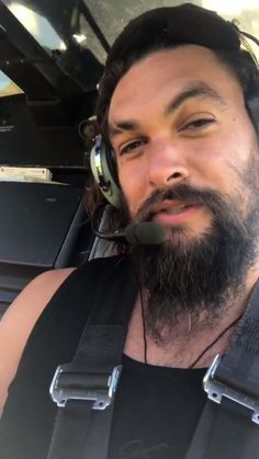 a man with headphones on sitting in an airplane