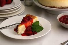 a slice of cheesecake on a plate with strawberries in the bowl next to it