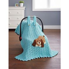 a blue crocheted bag with a brown dog on the front and back side