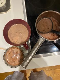 two pots on the stove with hot chocolate in them