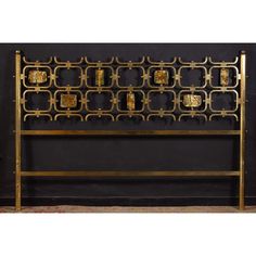 a gold metal headboard with decorative designs on it