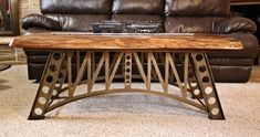 a wooden table sitting on top of a carpeted floor next to a brown couch