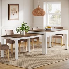 a dining room table and chairs in front of a window with an area rug on the floor