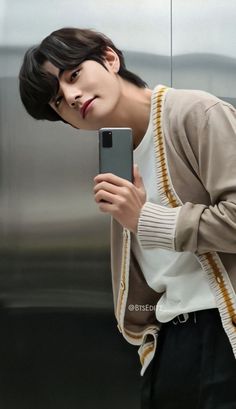 a young man taking a selfie with his cell phone