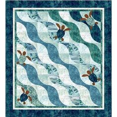 a blue and white quilt with fish on it's sides, in the middle of an ocean wave pattern