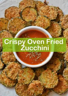 crispy oven fried zucchini on a plate with dipping sauce in the middle