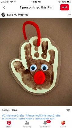 a handprinted christmas ornament with a red nose