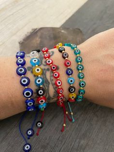 ------Price per Item------ Beautiful everyday evil eye beaded bracelets. Made with flat evil eye beads, string and brass beads, put together creating this bracelets that will keep you safe and in style at the same time. You can choose between 3 different styles. The all blue evil eye bracelet, or the colorful one, which comes in 2 different sizes. As you can see one has bigger evil eye beads and one are a bit smaller. All are size adjustable what makes them the perfect friendship/couples bracele Evil Eye Round Beads Friendship Bracelets For Festival, Evil Eye Friendship Bracelets With Round Beads For Festivals, Festival Evil Eye Friendship Bracelets With Round Beads, Bohemian Evil Eye Bracelet With Resizable Round Beads, Bohemian Friendship Bracelets With Evil Eye, Bohemian Beaded Bracelets With Evil Eye, Bohemian Beaded Evil Eye Bracelets, Bohemian Evil Eye Bracelet With Round Letter Beads, Bohemian Evil Eye Bracelet With Letter Beads