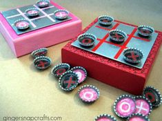 a pink and red box sitting on top of a table next to other items that are made out of bottle caps