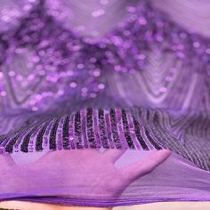 a close up view of the inside of a purple cloth with sequins on it