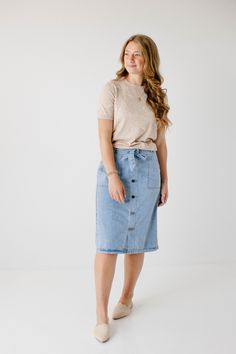 Create an instant feminine look wearing the 'Cassidy' Skirt! Featuring a button-front design and tie waist, this denim midi skirt makes a perfect choice for both casual or formal occasions. The soft, lightweight denim in a regular fit offers comfort, while the pull-on style allows easy wear. Pair the 'Cassidy' with a black tee and sneakers for a fun day in the city or running errands in town! 75% Cotton 25% Polyester Hand Wash Cold Do Not Bleach Hang to Dry Low Iron if Needed Model Height 5'7" | Light Weight Outfits, Button Down Shirt With Skirt, Amish Fashion, Casual Denim Skirt Outfit, Modest Skirt Outfits, Modest Jean Skirts, Stylish Petite Woman, Feminine Street Style, Soft Feminine Style