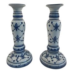 two blue and white vases sitting side by side on a white surface with dots