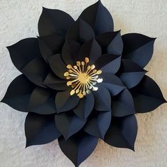 a black paper flower with gold accents on it