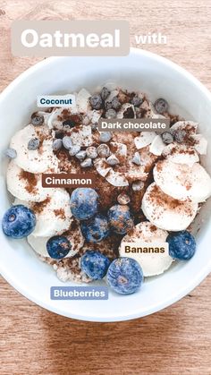 a bowl filled with cereal and blueberries on top of a wooden table