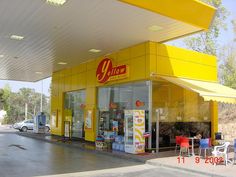 a yellow store front with chairs and tables outside