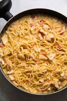 a skillet filled with pasta and chicken