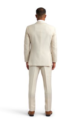 A slim tan suit with two buttons and a notch lapel. Beige Suits With Welt Pockets For Business Casual, Beige Double Breasted Suit For Business Casual, Beige Business Casual Suits With Welt Pockets, Classic Beige Double Breasted Suit With Lapel Collar, Beige Single Breasted Tuxedo Suit, Beige Single-breasted Tuxedo Suit, Beige Three-piece Suit With Notch Lapel, Beige Single Button Business Casual Suit, Tailored Beige Suit With Lapel Collar