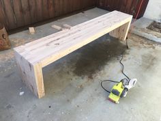 a bench made out of wood with a corded sander on the ground next to it