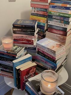 a pile of books sitting next to a candle