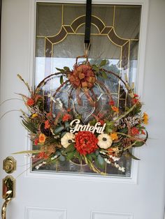 the front door is decorated with an autumn wreath and welcome sign that reads, grateful