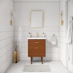 a bathroom with white tile walls and flooring has a wooden cabinet in the corner