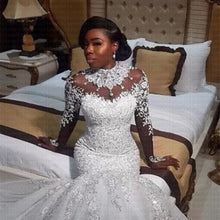 a woman in a wedding dress sitting on a bed