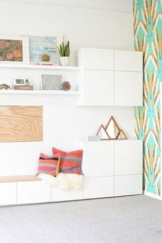 an instagramted photo of a bedroom with white cabinets and colorful wallpaper on the walls