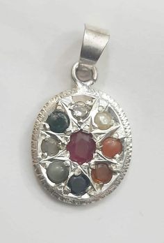 Navaratna is a combination of nine gemstones (Ruby, White Topaz, Iolite, Citrine, Emerald, Red Coral, Pearl, Cats eye and Hessonite Garnet) worn in a single ornament. What is the benefits of Navaratna Pendant ? It can avoid negative impulses and getting positive energy. Navaratna is providing good healthy conditions and balanced emotions. While wearing these auspicious stones, people will get concentration in making exact decisions in life, getting peace of mind and wealth. Weight- 3 Gram Length Hessonite Garnet, Cats Eye, Red Coral, Precious Gemstones, White Topaz, Positive Energy, Gemstone Pendant, Citrine, Garnet