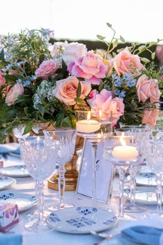 the table is set with plates, glasses and candles for an elegant dinner or party