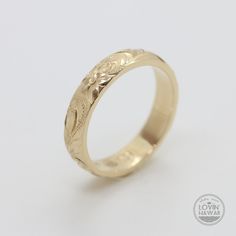 a yellow gold wedding ring with an intricate design