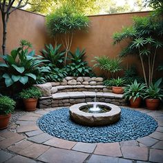 a small garden with a fountain surrounded by plants